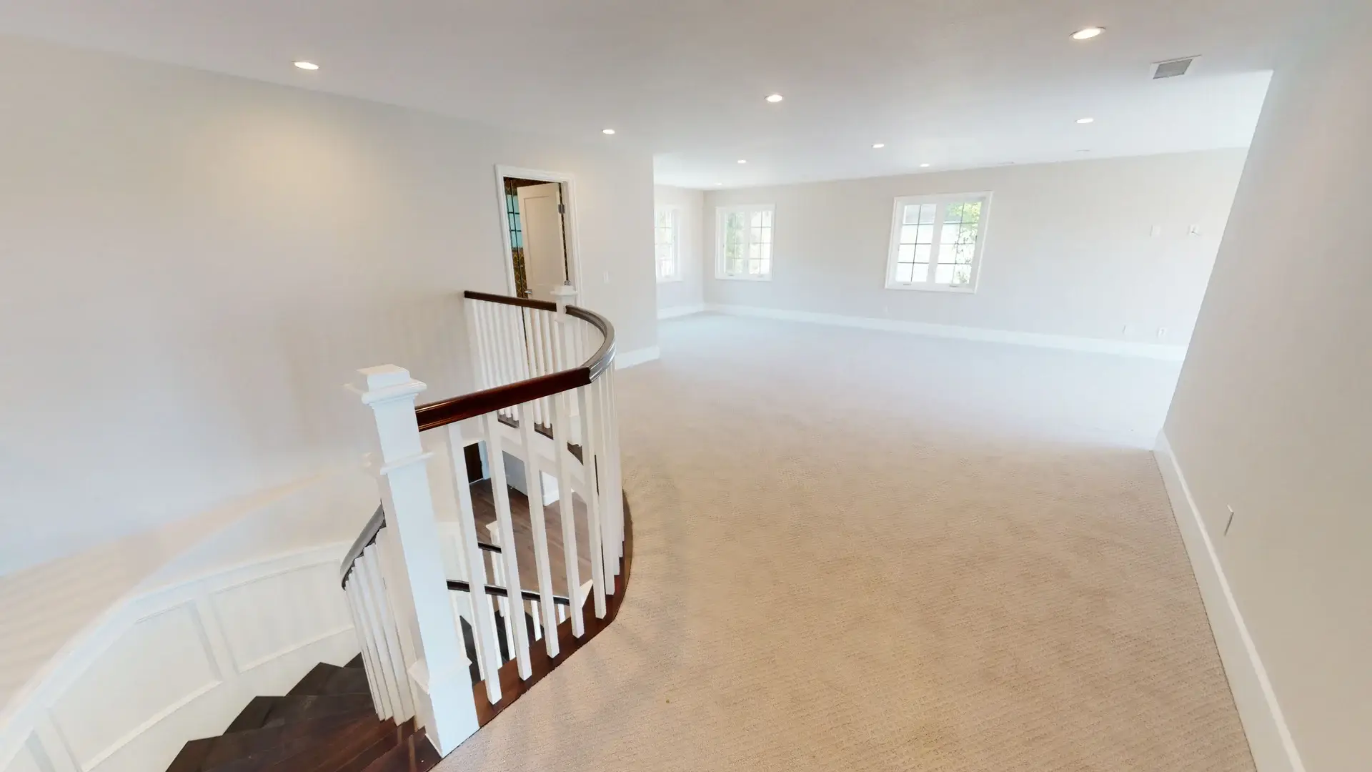 Bright and spacious upstairs hallway featuring new carpet, recessed lighting, and natural light from multiple windows, part of a complete whole house makeover renovation.