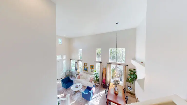Two-story living and dining area with tall flat ceilings and upper windows, offering ideal conditions for a future loft or second-story room addition