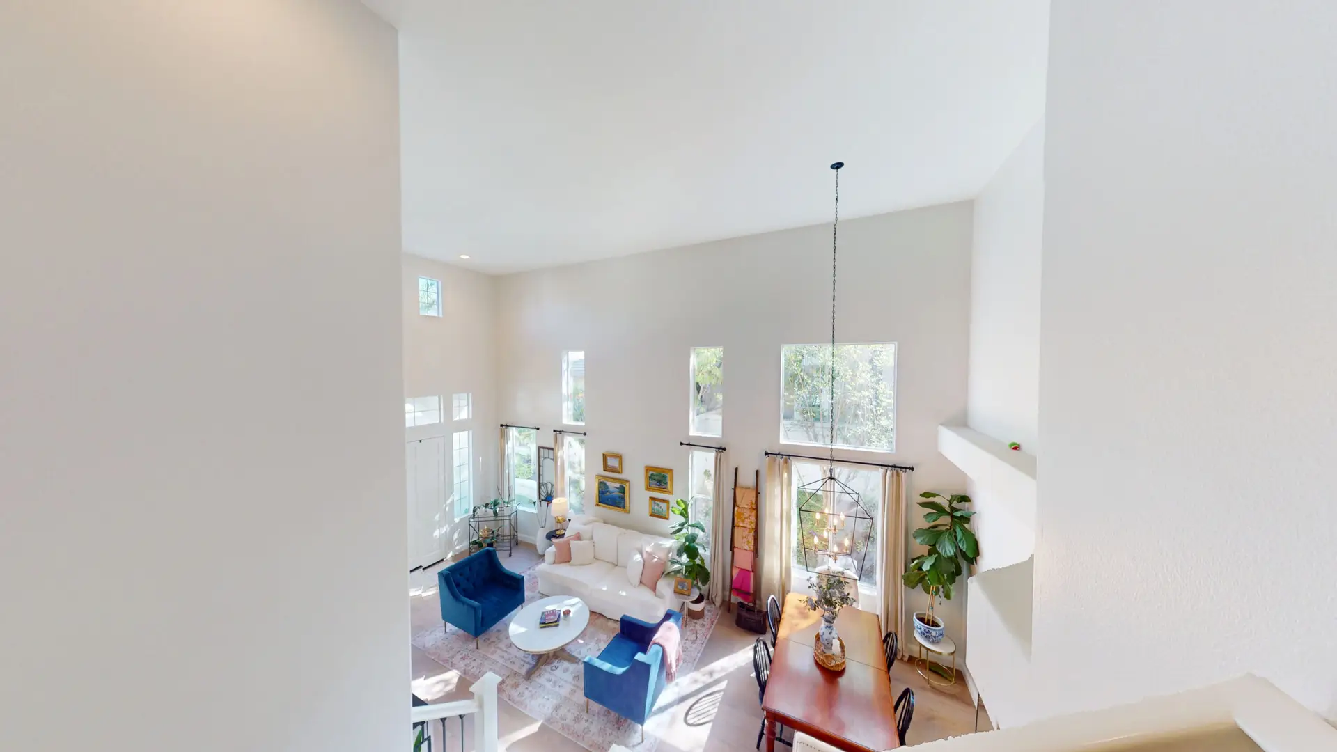 Two-story living and dining area with tall flat ceilings and upper windows, offering ideal conditions for a future loft or second-story room addition