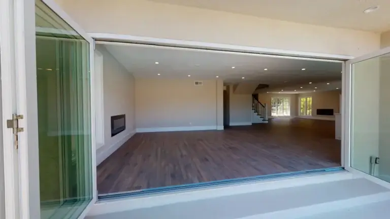Open concept living room with recessed lighting and folding glass doors opening to the backyard