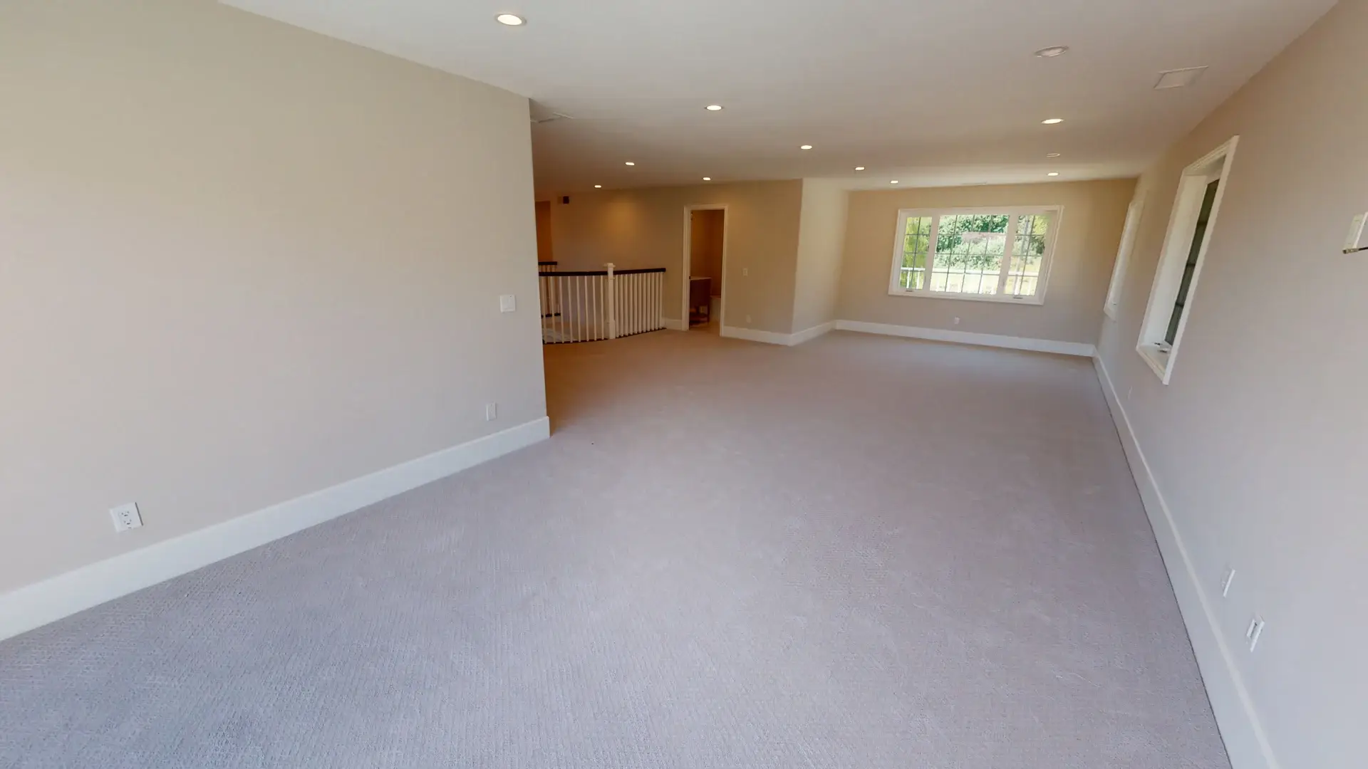 Bright and expansive upstairs living area with fresh carpeting, recessed lighting, and updated trim, showcasing the final result of a whole house makeover in Orange County.