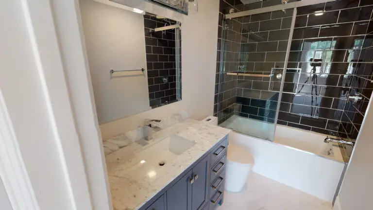 Home remodeling contractor completing a bathroom remodel in Orange County with a glass-enclosed tub