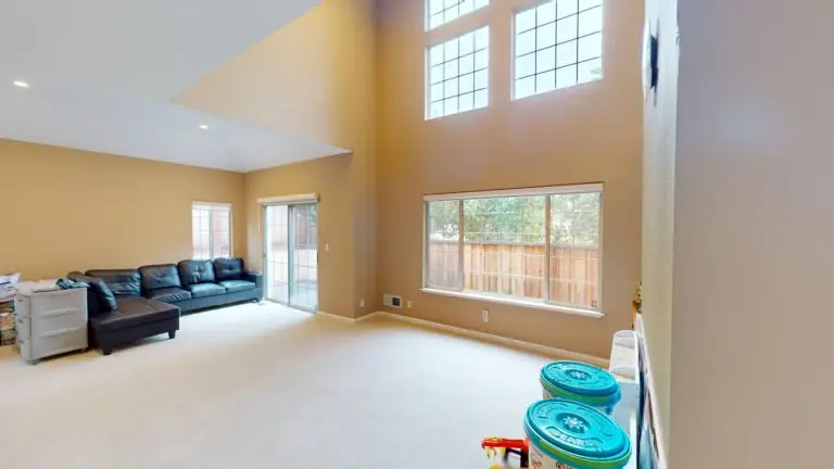 Tall-ceiling family room in the home with natural light and unused upper wall space, ideal for adding a second-story room or loft