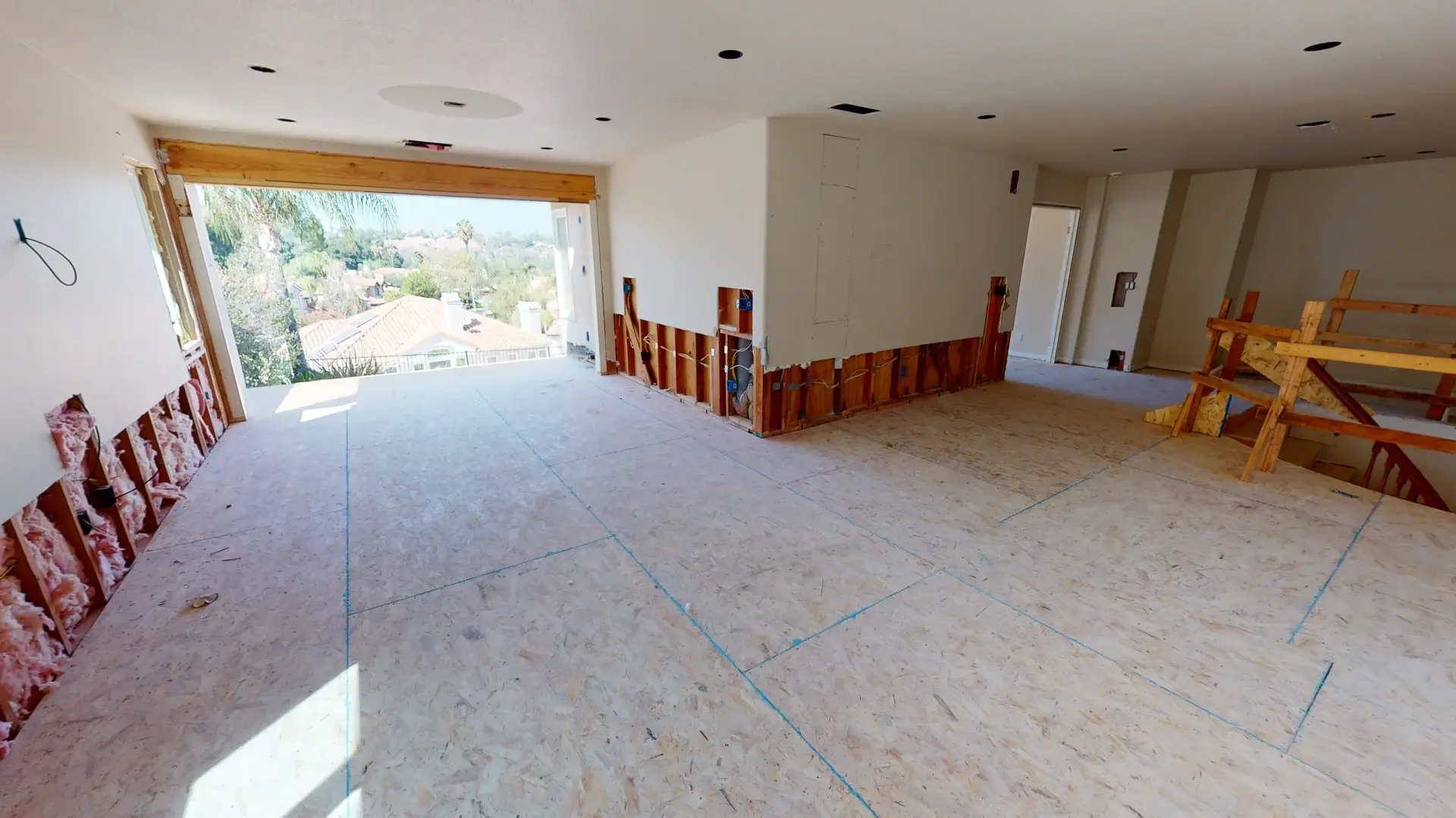 Upper level of a whole house makeover project showing new plywood subflooring, exposed lower wall framing, electrical rough-ins, and panoramic view potential, captured during a full home transformation in Orange County, California.