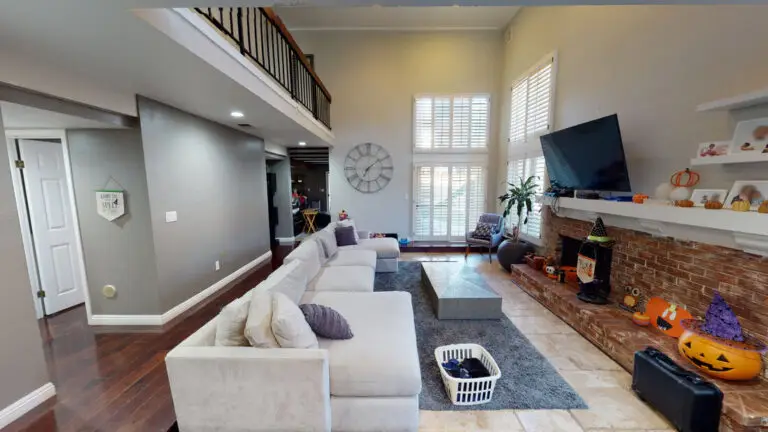 Spacious living room with vaulted ceilings and visible loft railing in Orange County, showcasing the potential for a future loft addition