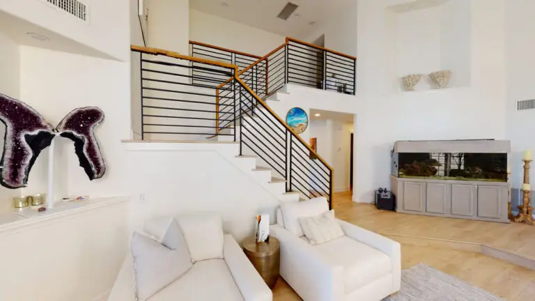 Modern staircase remodel in a high ceiling living room, showcasing loft addition potential and sleek horizontal railing design in Orange County home