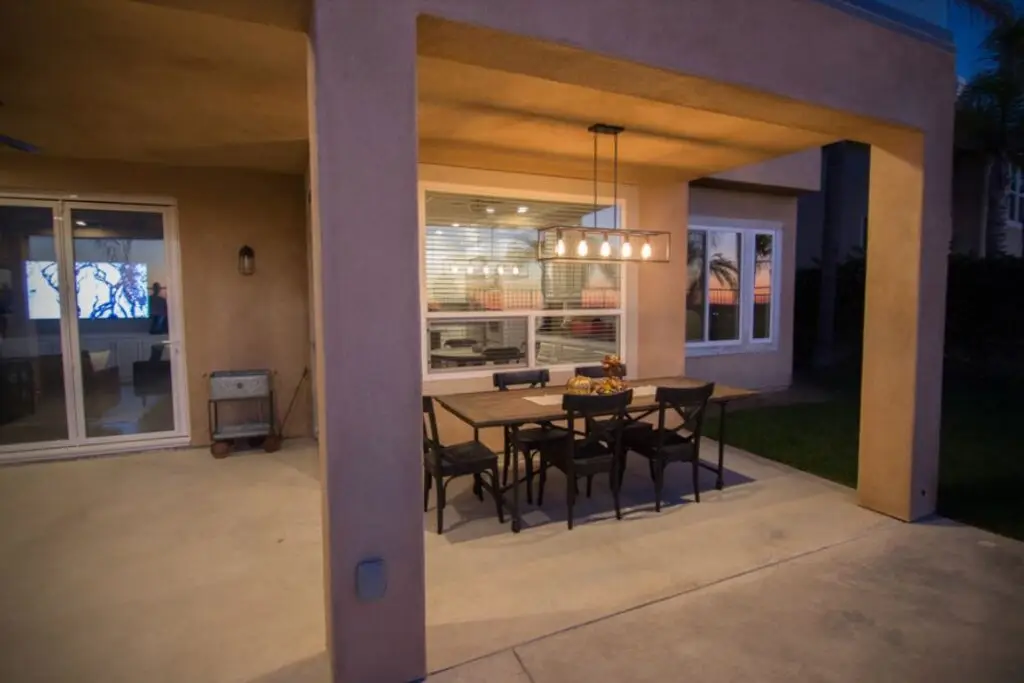 Modern California room addition in Trabuco Canyon featuring a covered outdoor dining space with pendant lighting and stucco columns