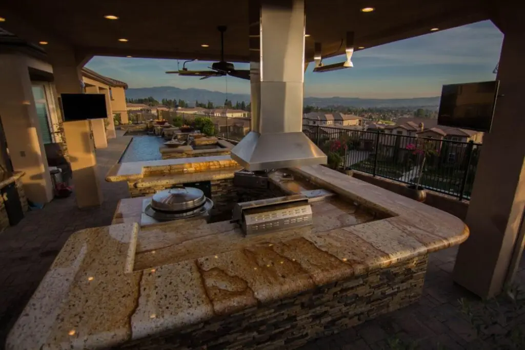 Home remodeling contractor designing and building a custom outdoor kitchen in Orange County, featuring stone countertops, built-in appliances, and a covered entertainment area.