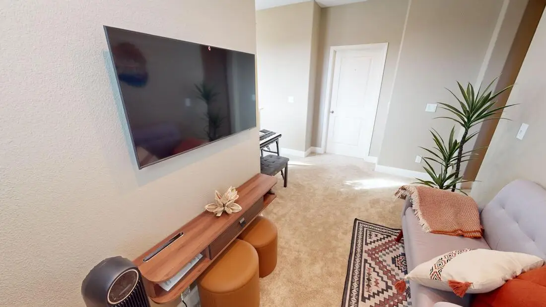 Another view of the finished Rocklin teen hangout loft with a television and seating