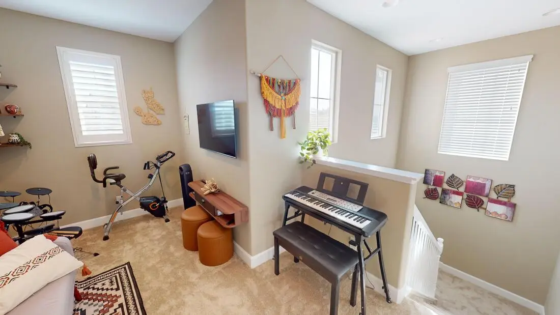 Finished loft room in Rocklin used as a teen hangout space, with windows and carpet